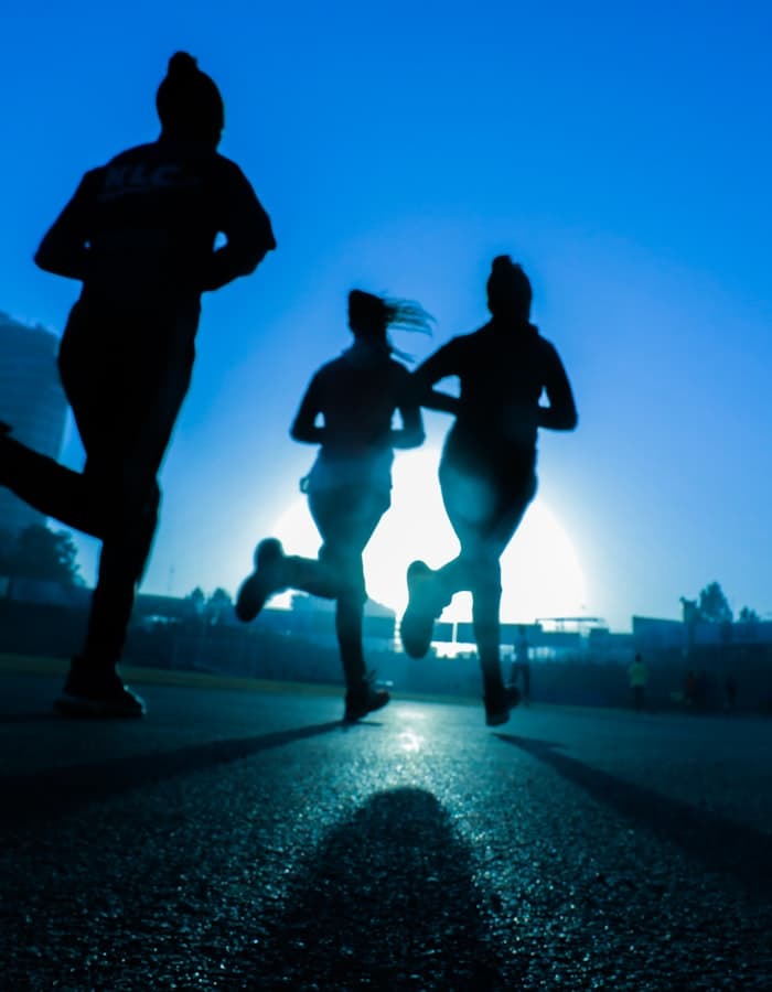 Group of runners training together at sunrise